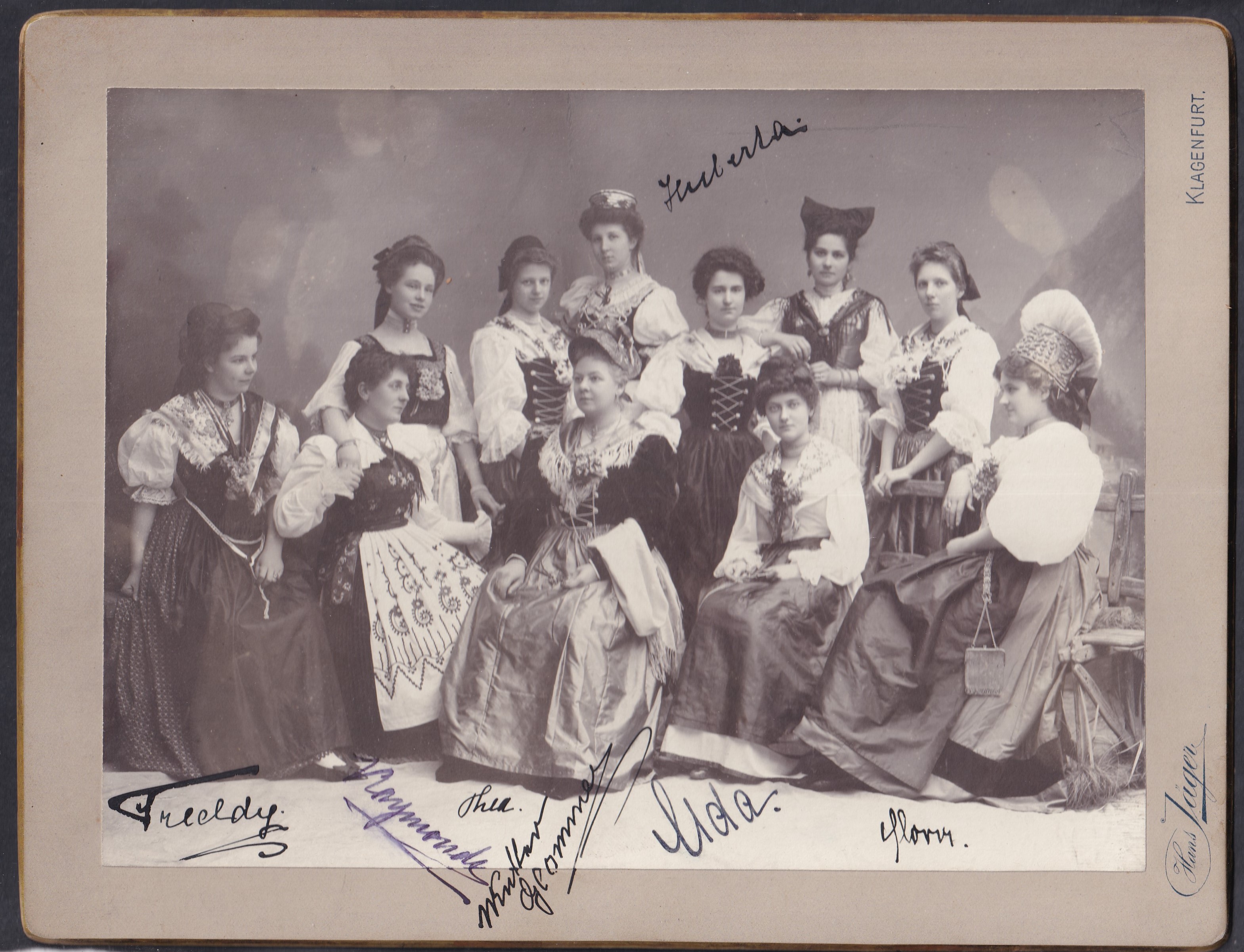 IMG_20260811_0067 cca. 1900–1910 Klagenfurt – karintiai népviseletbe öltözött hölgyek – nagyméretű kabinetfotó, Hans Jäger műterme - nagyméretű, tizenegy alakos, népviseletes kompozíció és aláírásokkal
